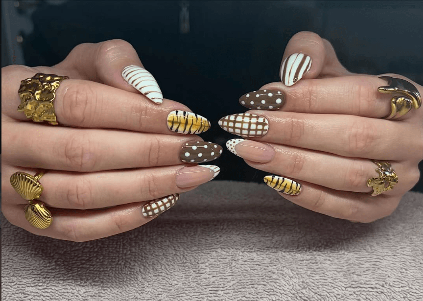Forgyldte stiletto negle med striber, prikker og ternede detaljer